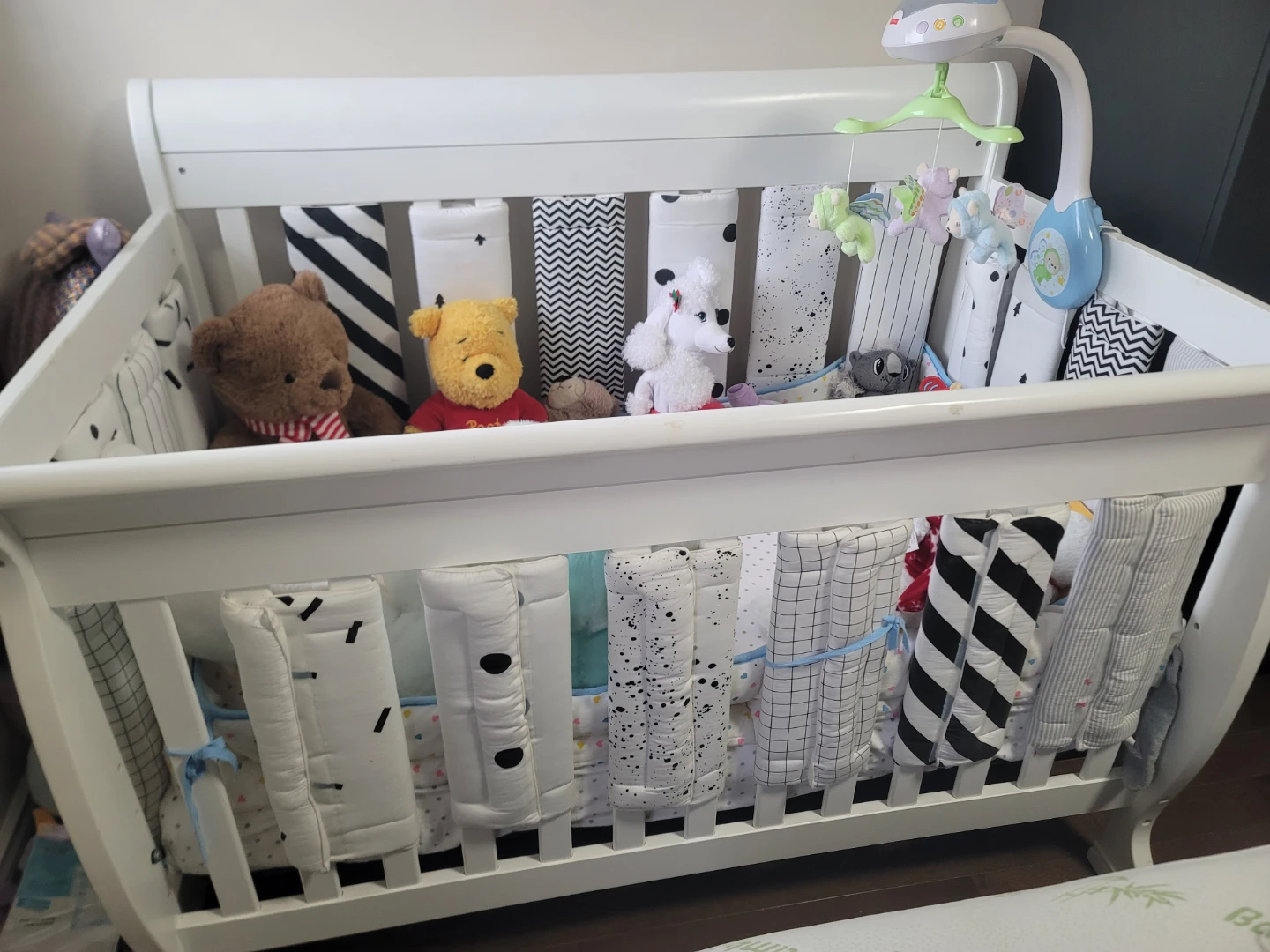 White Baby Crib with Toys and Mobile