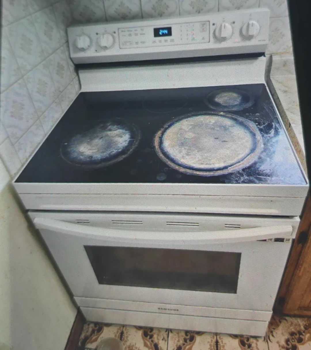 White Samsung Electric Range with range hood.