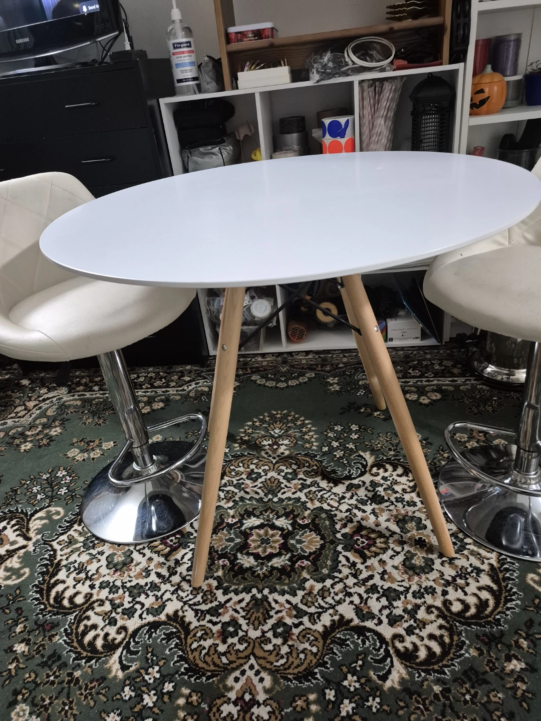 White oval table and two bar stools