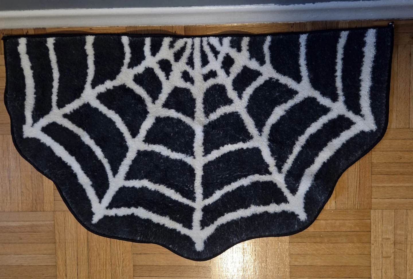 Black and white spiderweb shaped accent rug