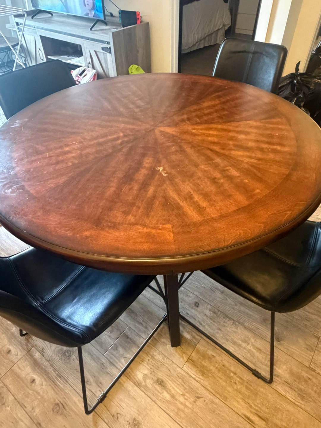 Round cherry wooden dining table with four black chairs - photo 2