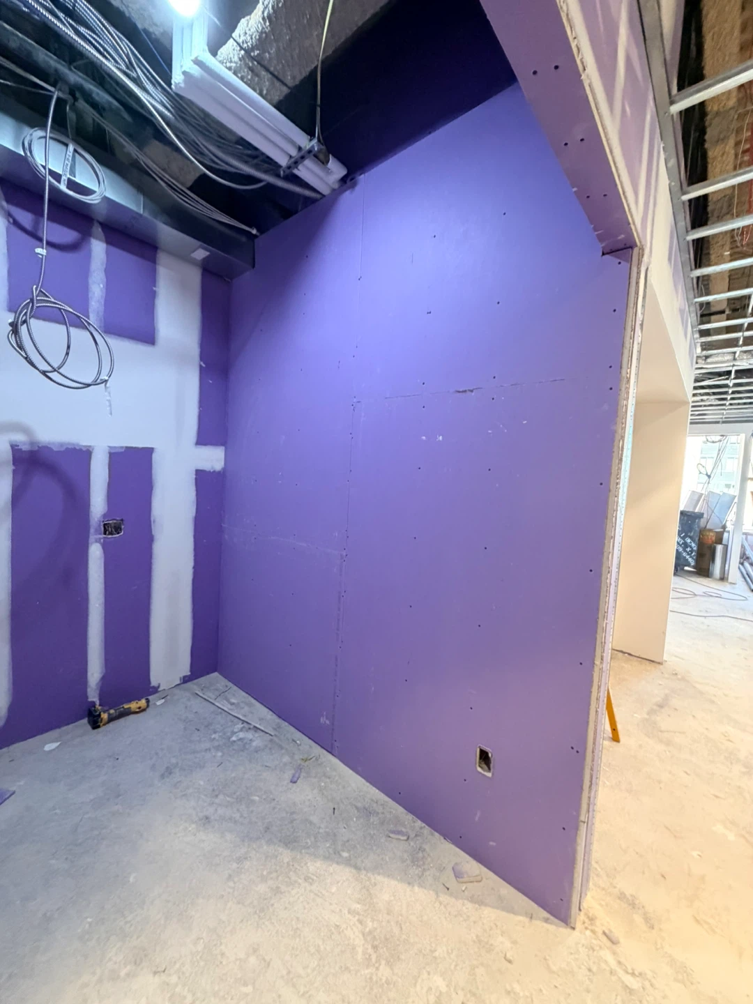 Construction Site Hallway with Drywall and Exposed Utilities