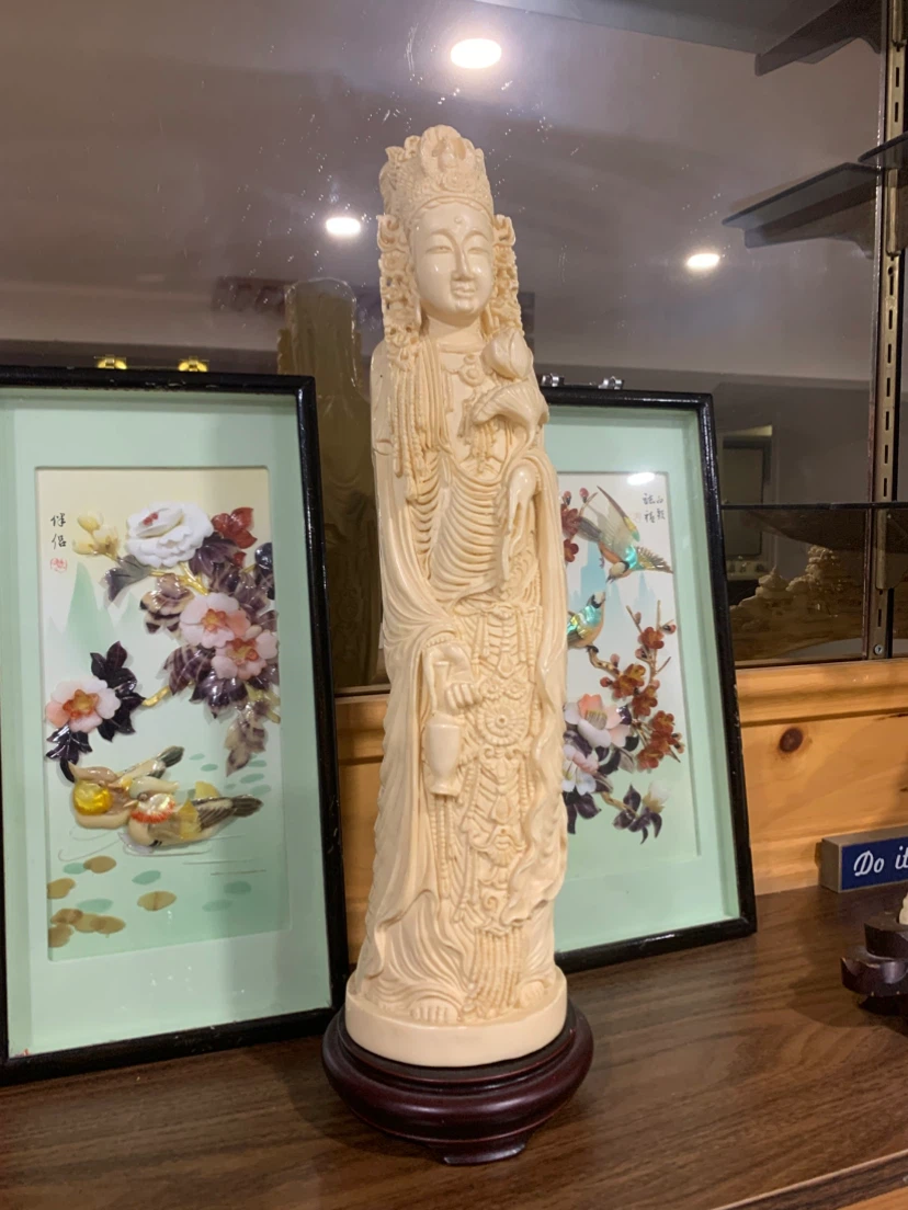 Cream Colored Figurine on Wooden Base