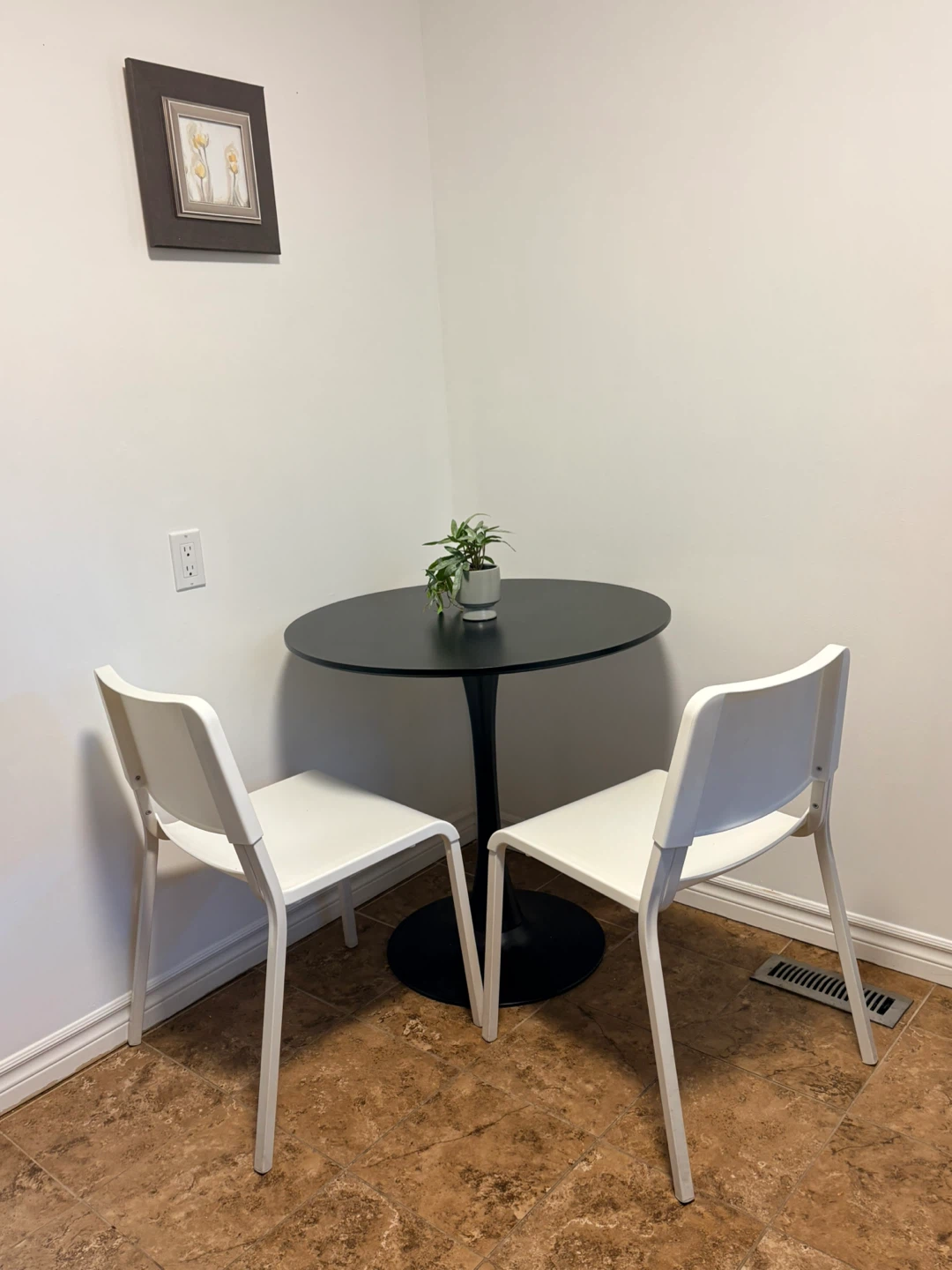 Round Black Dining Table with Two White Chairs