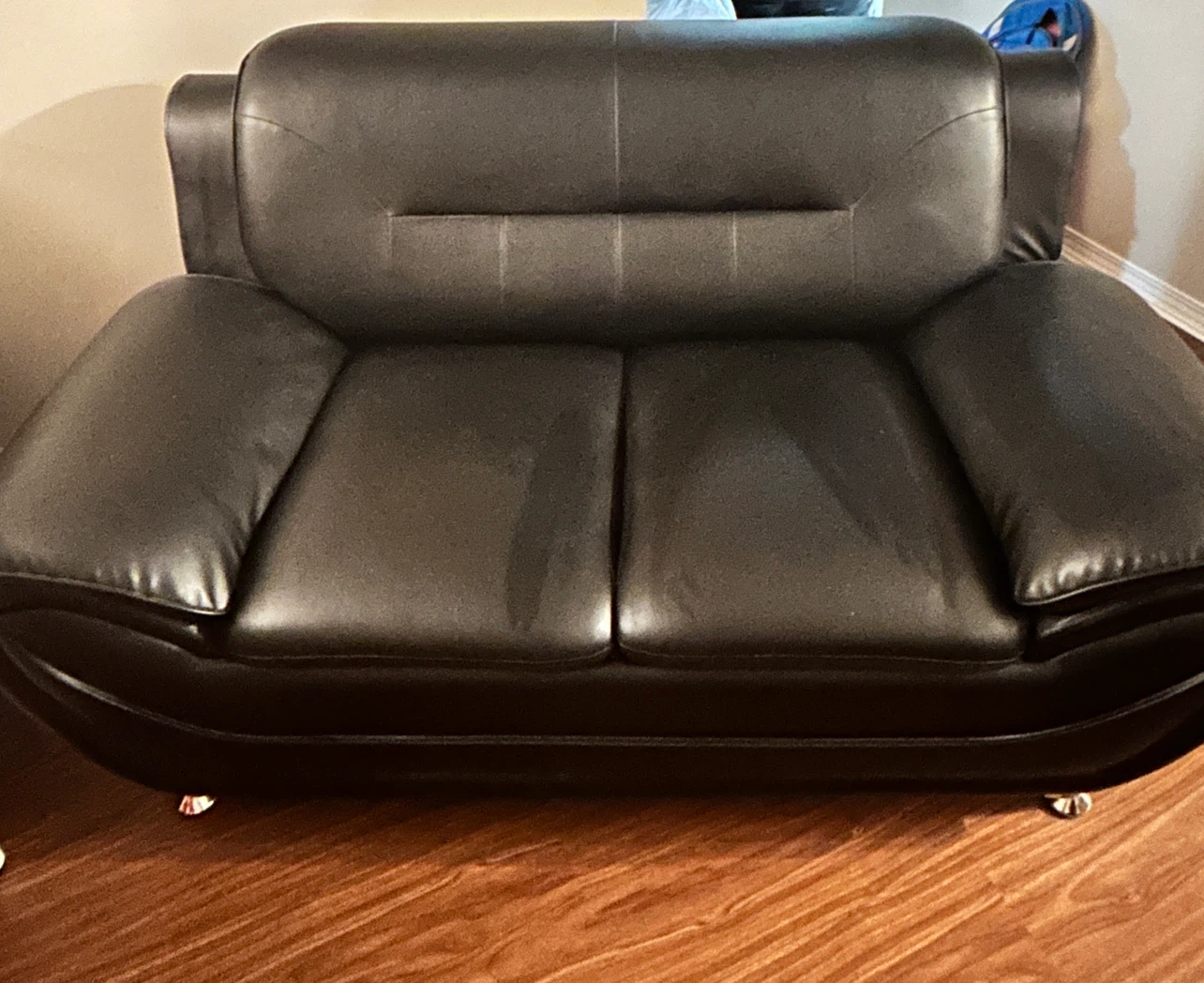 Black faux leather loveseat and a single sofa