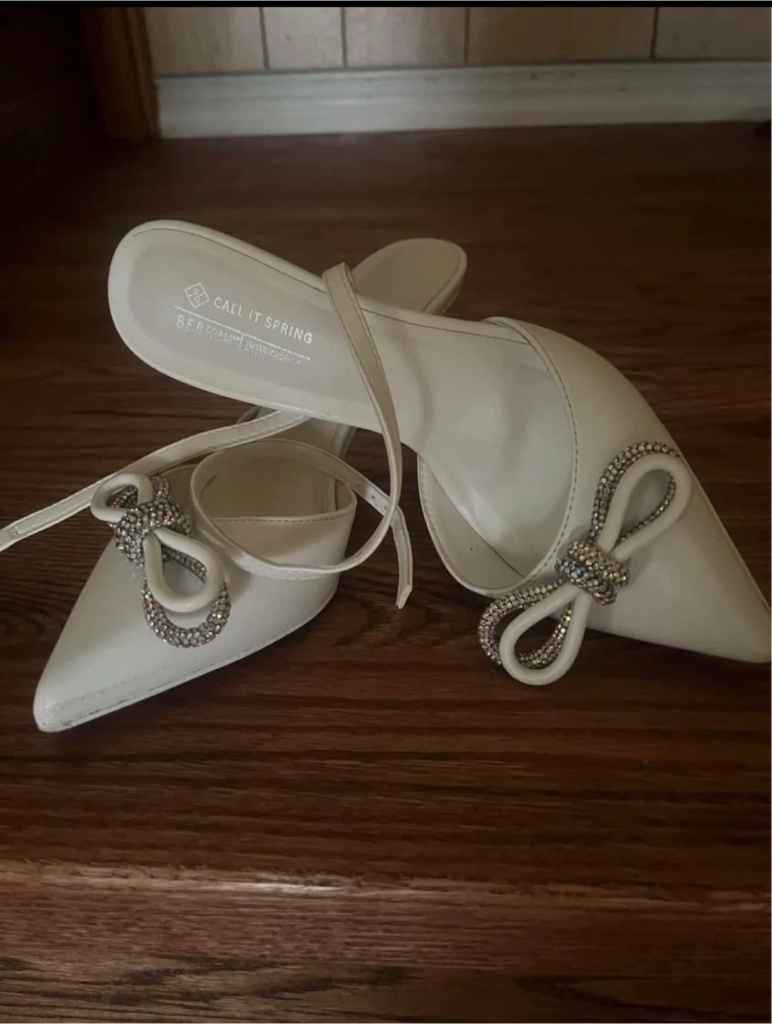 Call It Spring white heels with rhinestone bow