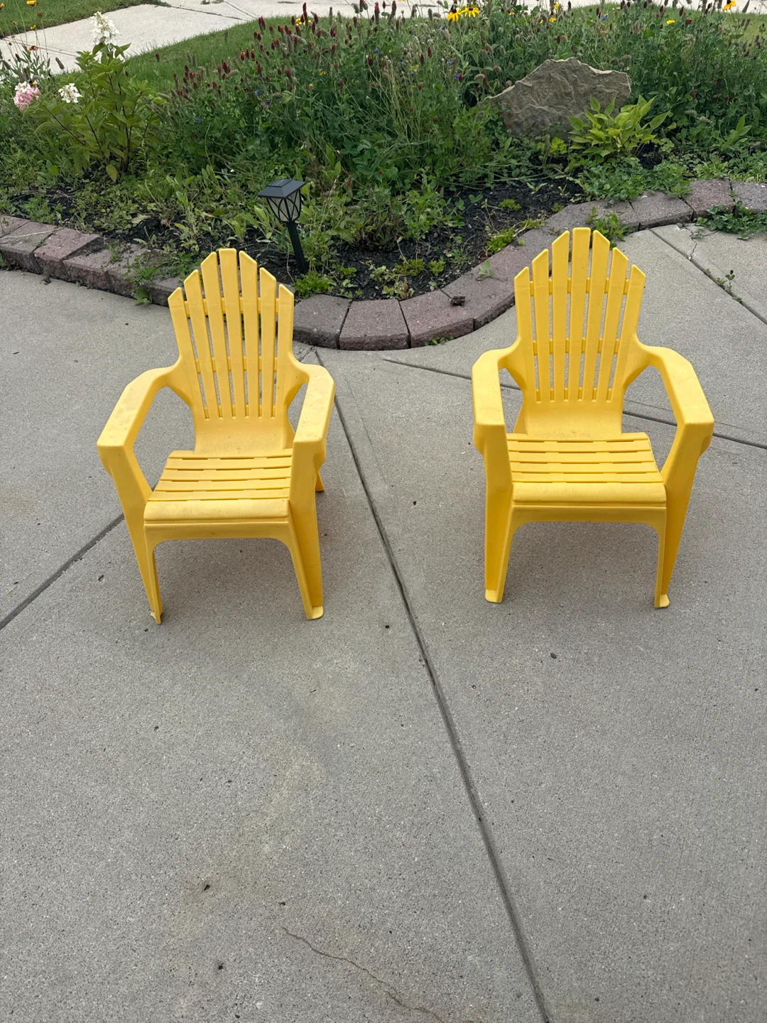 Two Yellow Plastic Adirondack Chairs