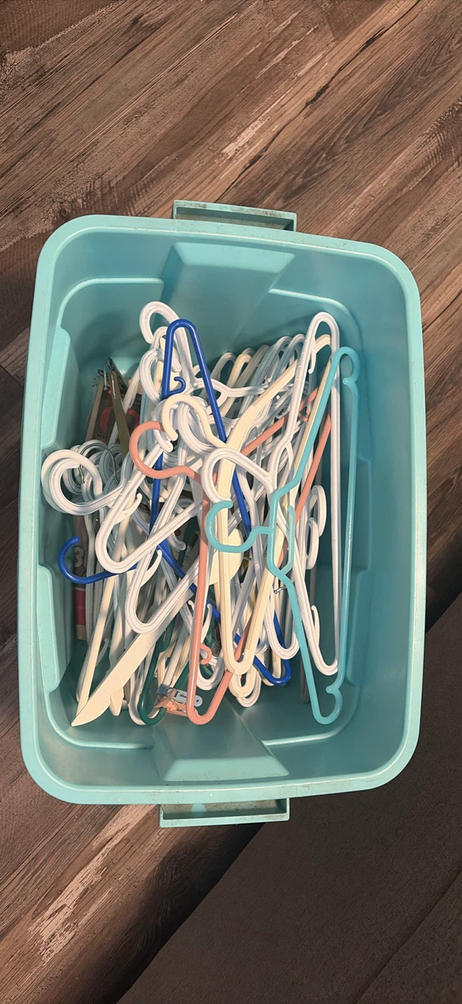 Assorted Plastic Clothes Hangers in Storage Bin