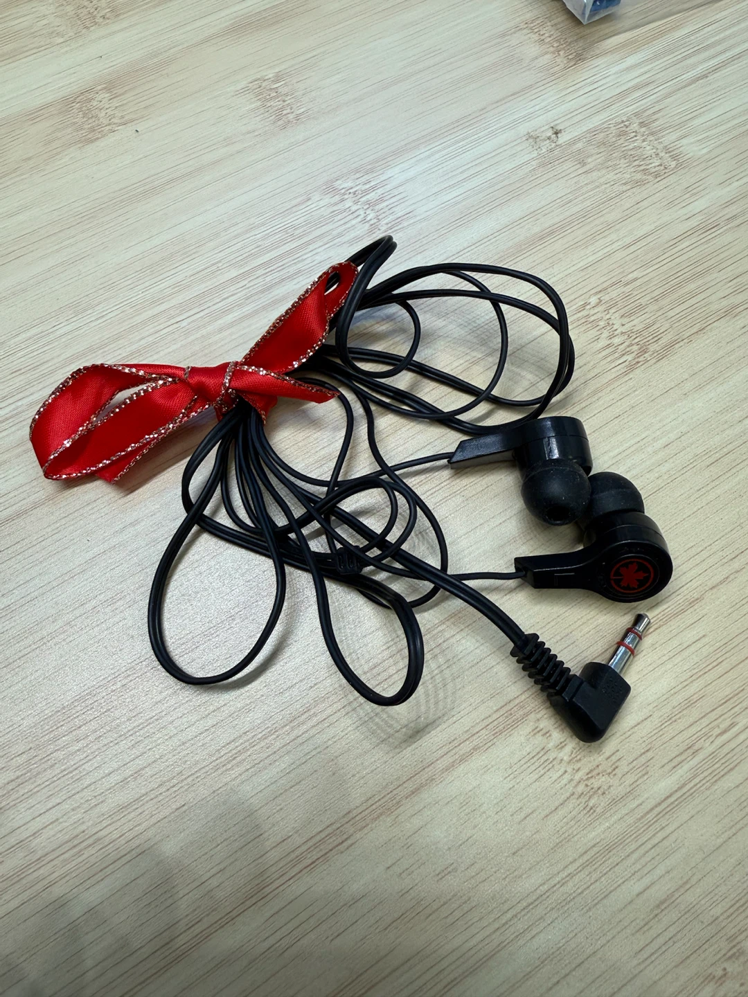 Black wired earphones with maple leaf logo