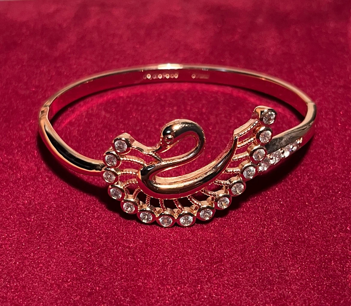 Rose gold tone swan hinged bangle bracelet