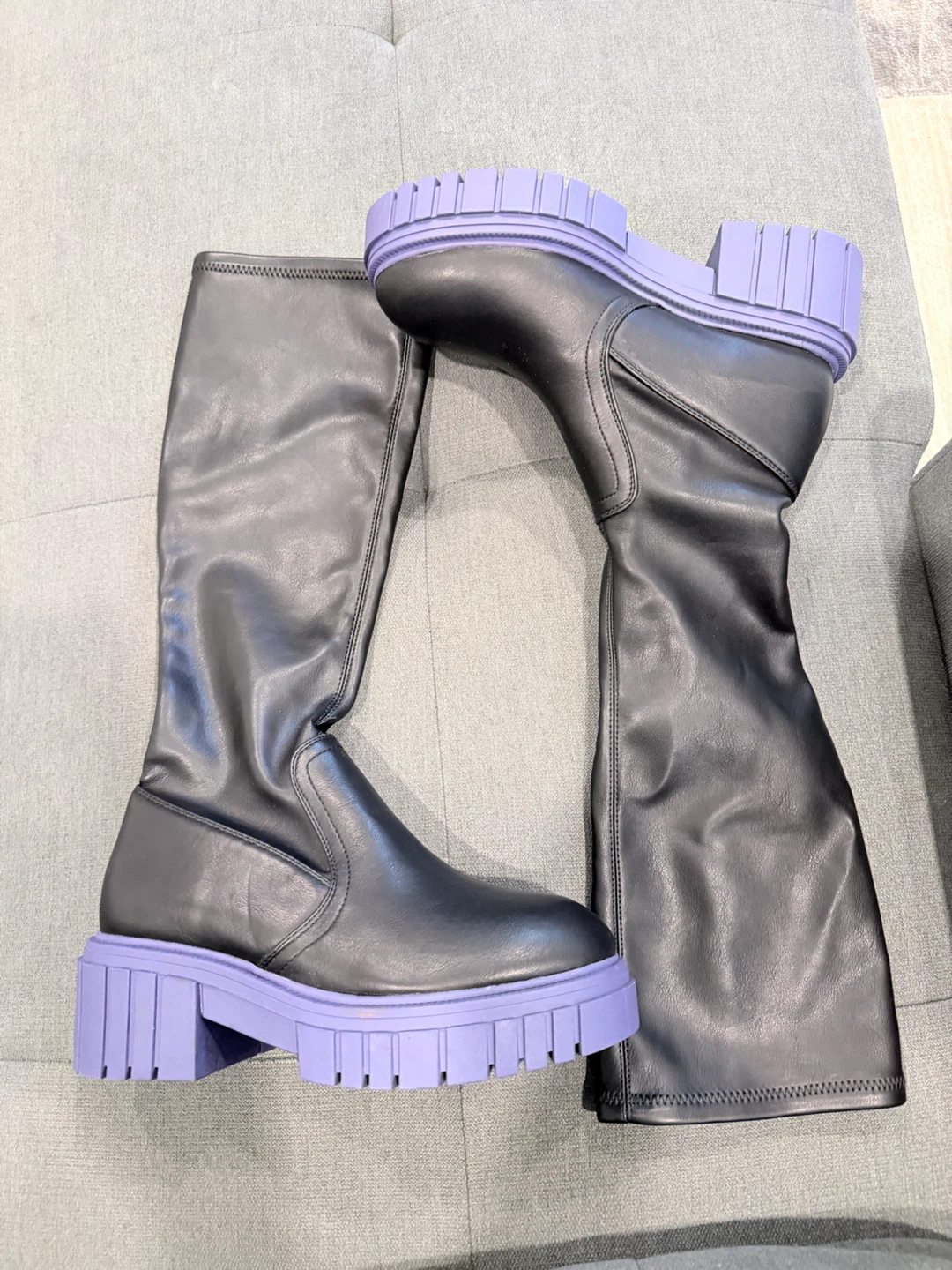 Black knee-high boots with purple soles
