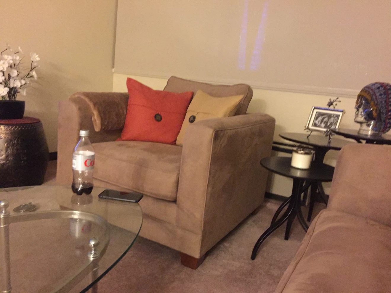 Tan/taupe Upholstered Armchair with decorative pillow.