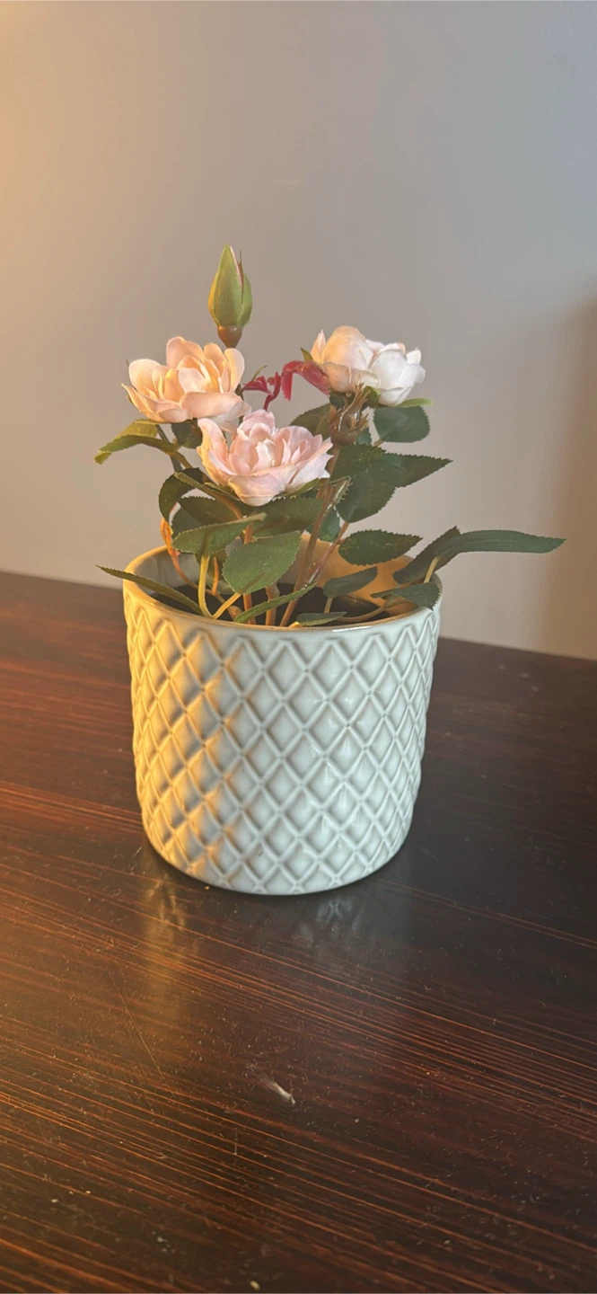 Artificial pink rose in textured ceramic pot