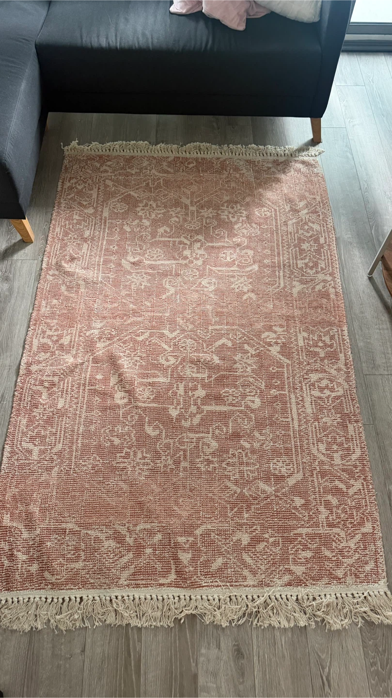 Terracotta and cream patterned area rug with fringe