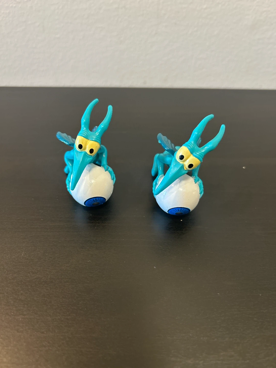 Two Blue Winged Creature Figures with Eyeballs