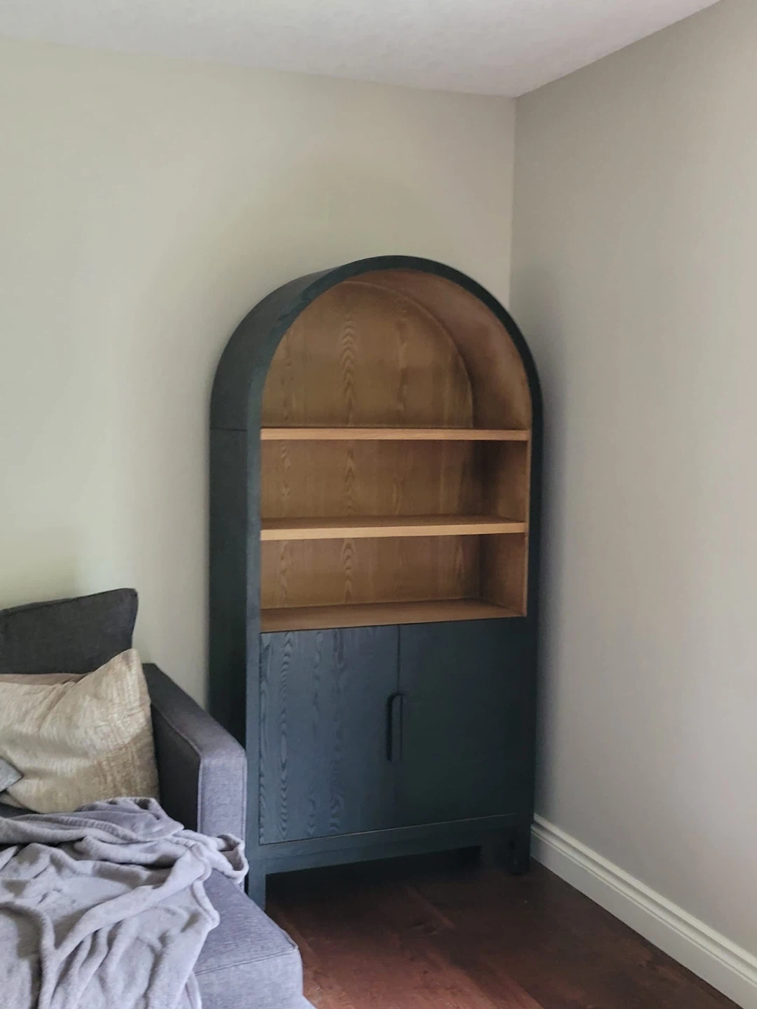 Arched wooden cabinet with shelving