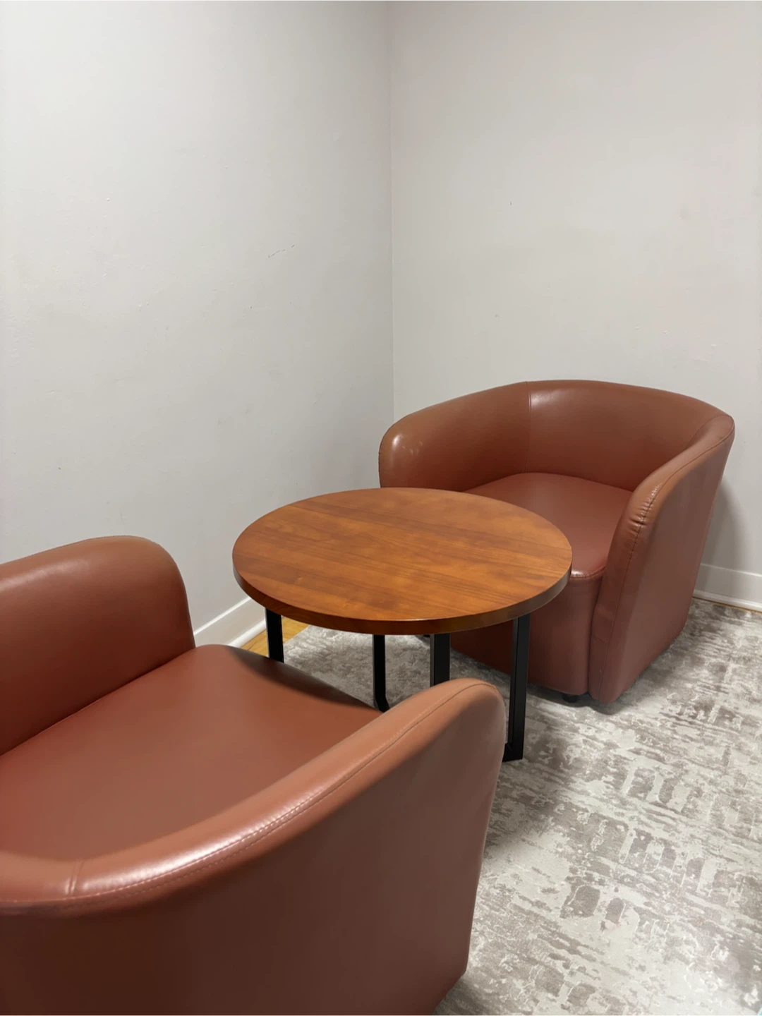 Two Brown Faux Leather Barrel Chairs with coffee table
