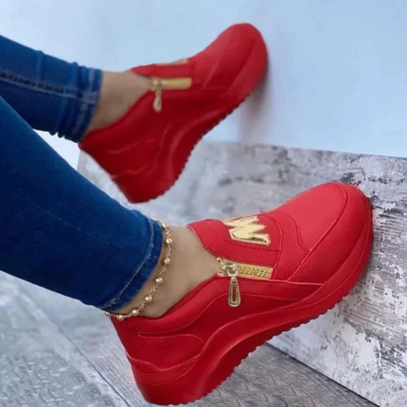 Red slip-on sneakers with gold M detail