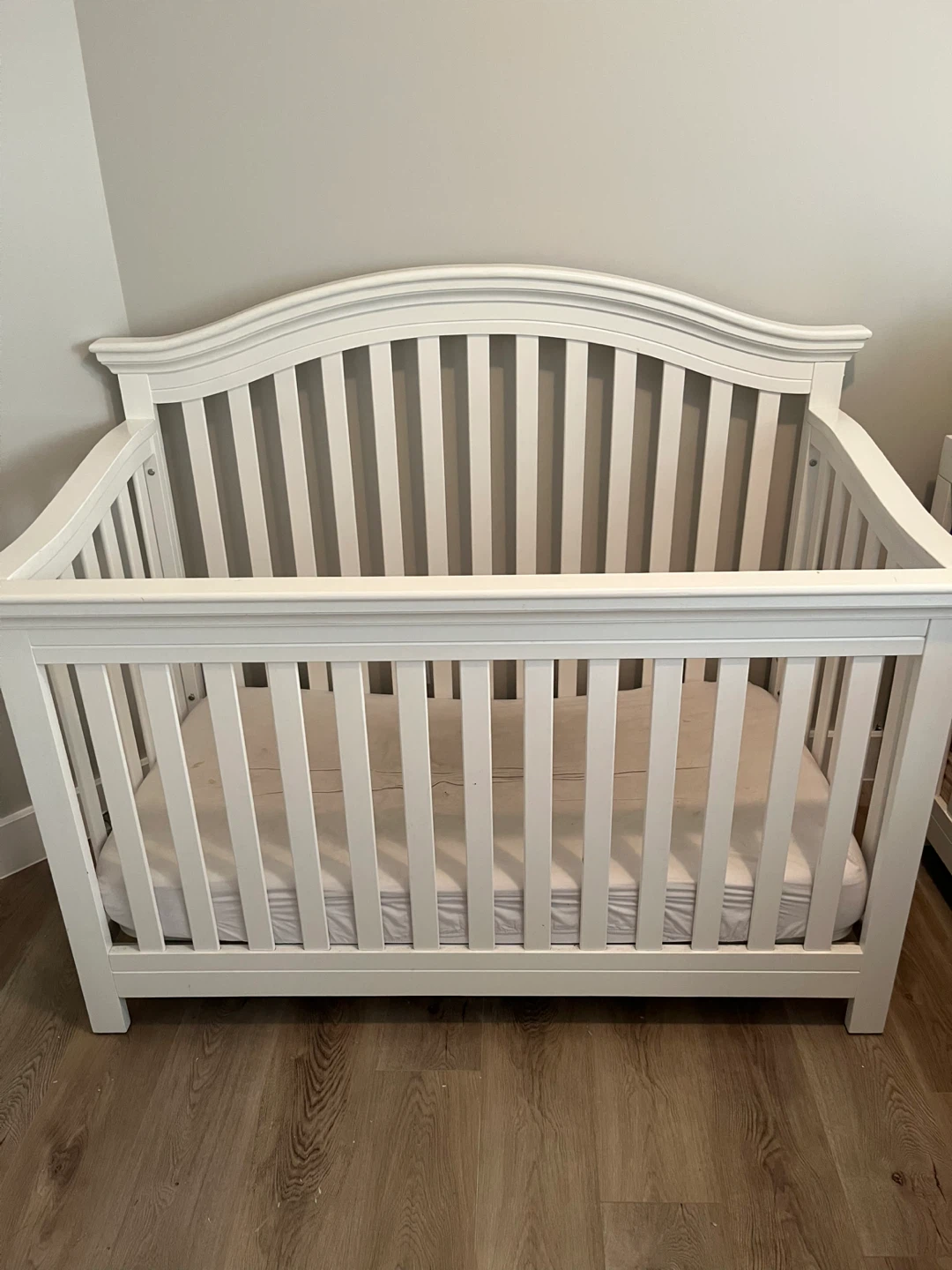 White arched wooden baby crib