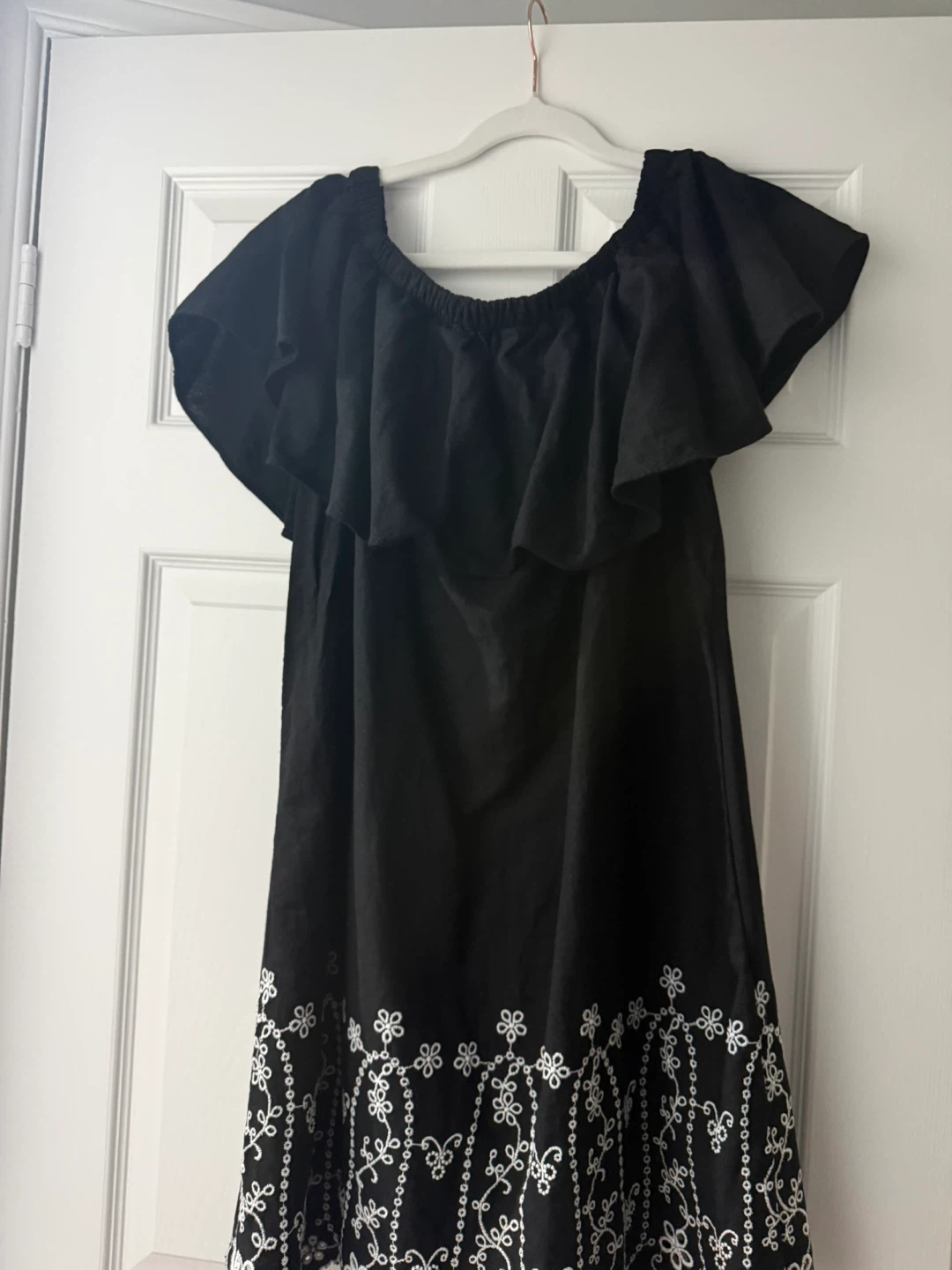 Black off-the-shoulder dress with white embroidery