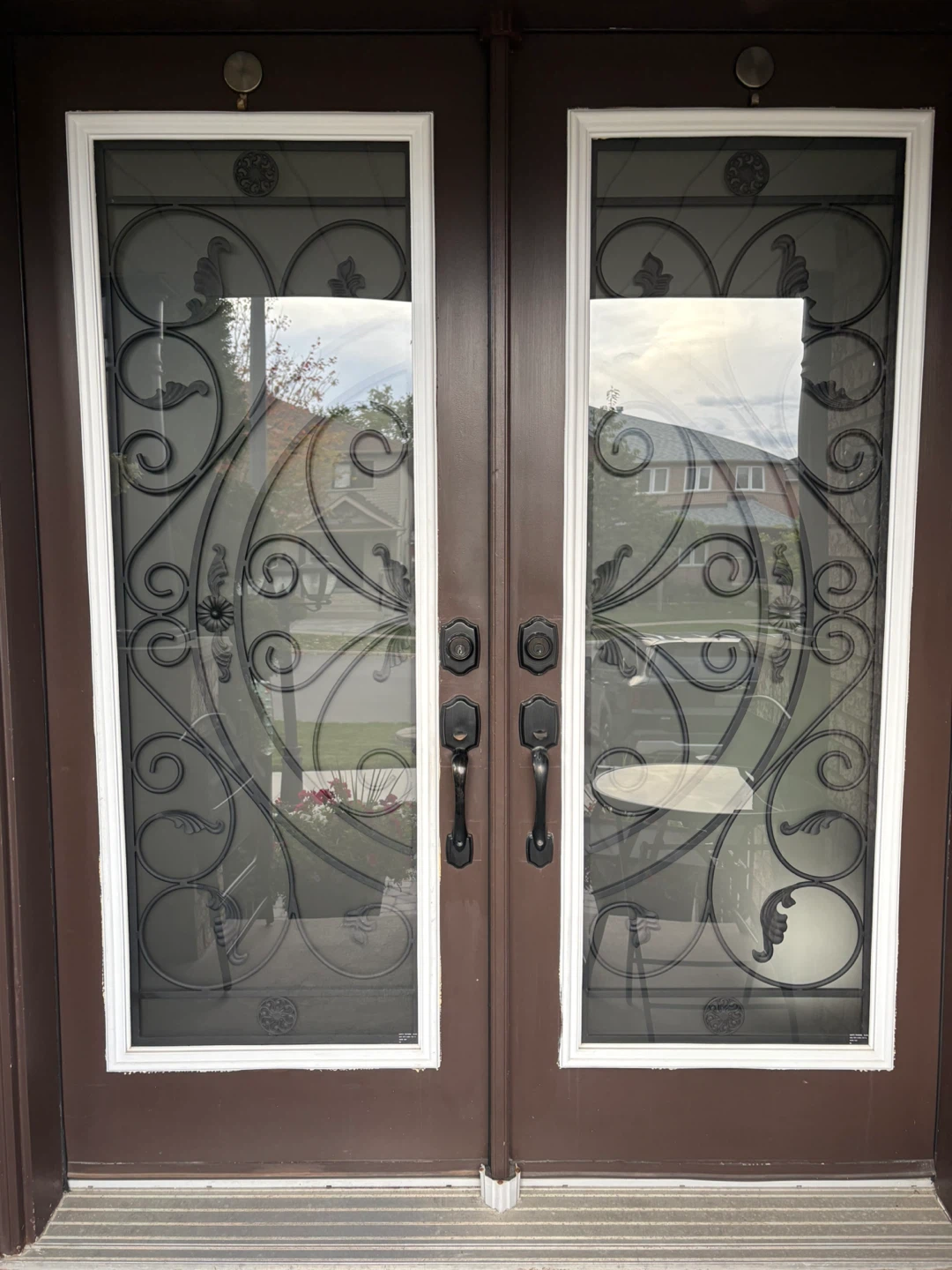 Double entry doors with wrought iron inserts