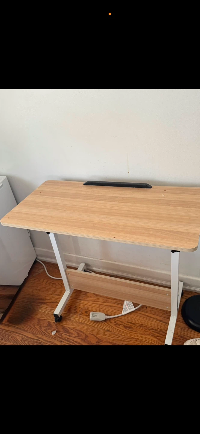 Black mesh office chair and light wood rolling desk
