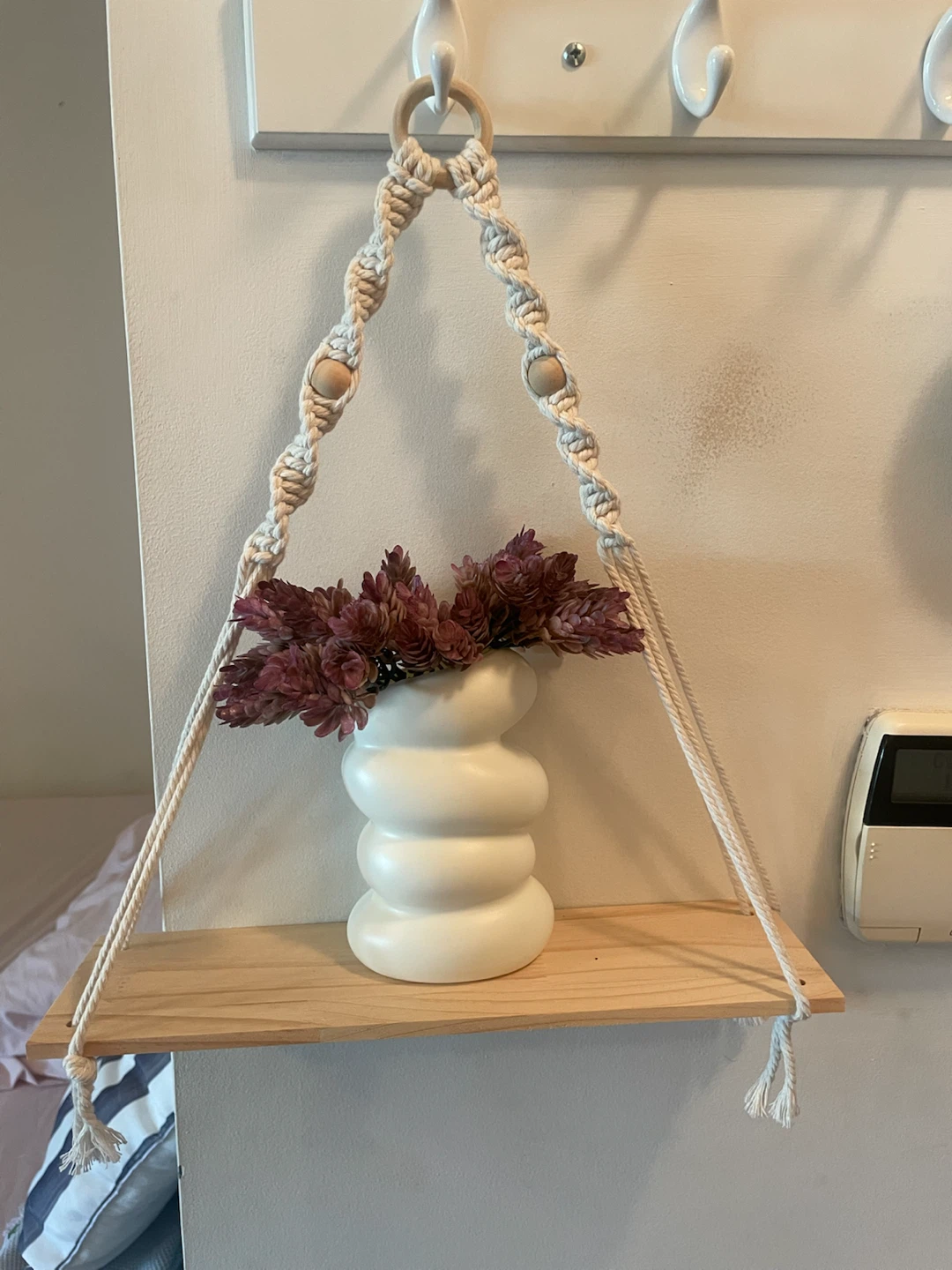 Hanging shelf with white vase and flowers