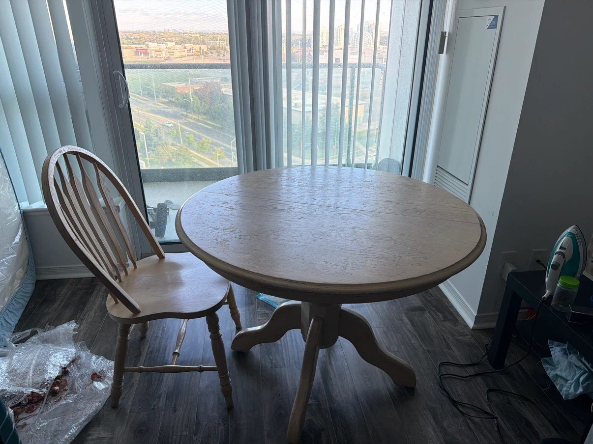 Round wooden dining table with one matching chair