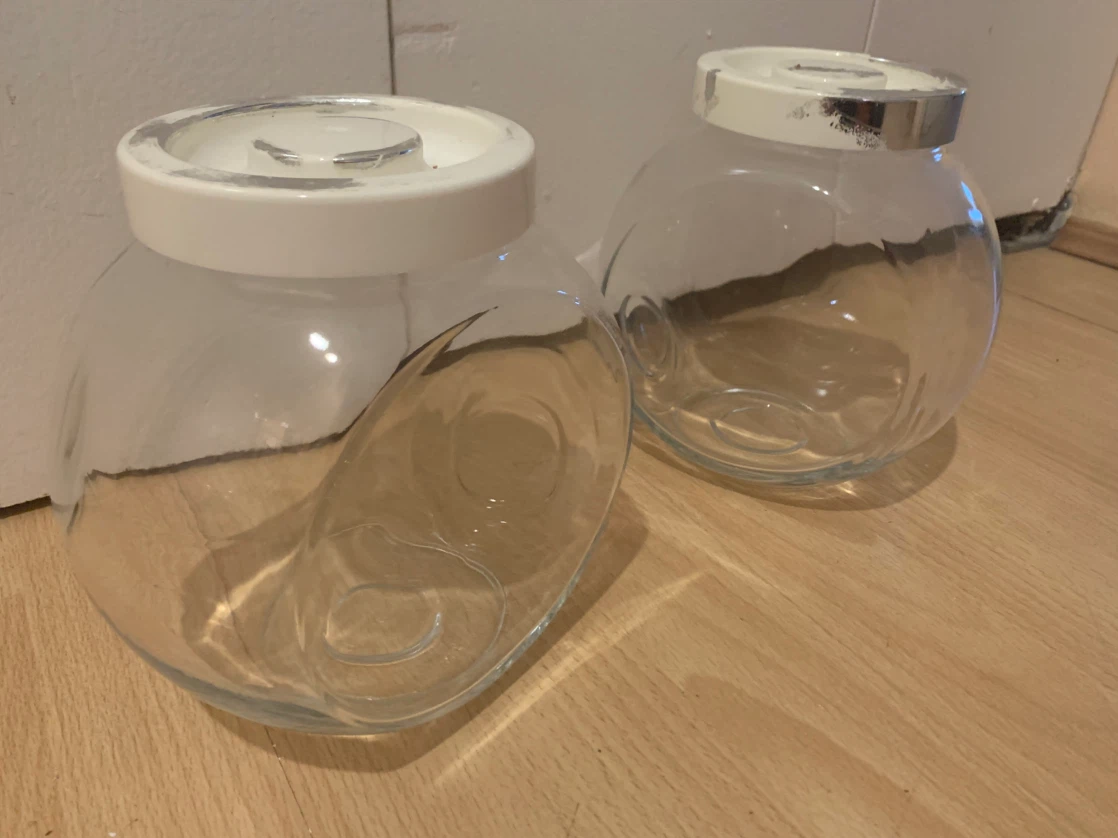 Two glass storage canisters with white lids
