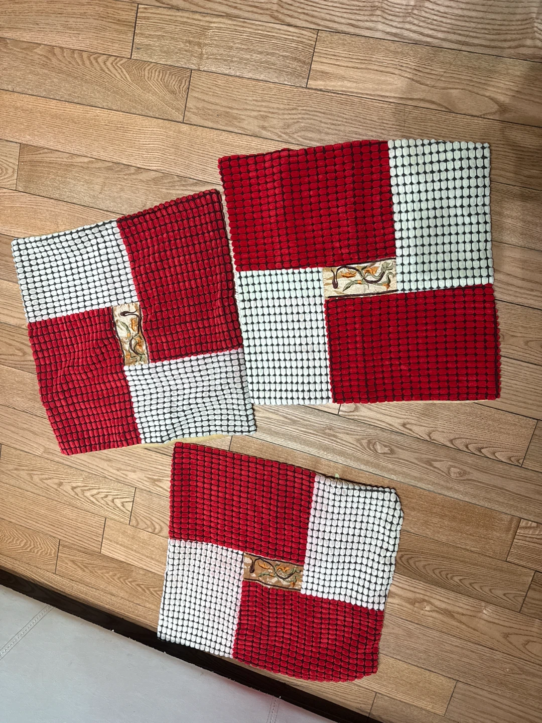 Three red and white patterned throw cushion covers