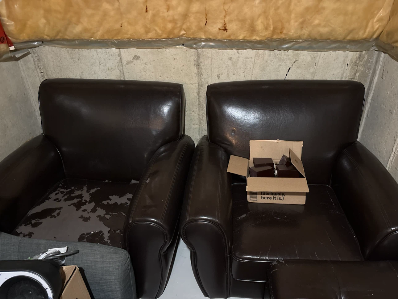 Two dark brown faux leather armchairs