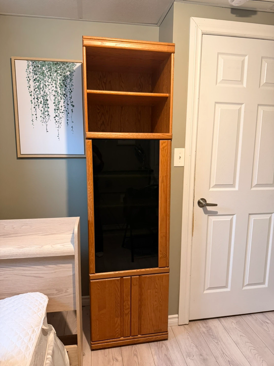 Tall oak storage unit with glass door