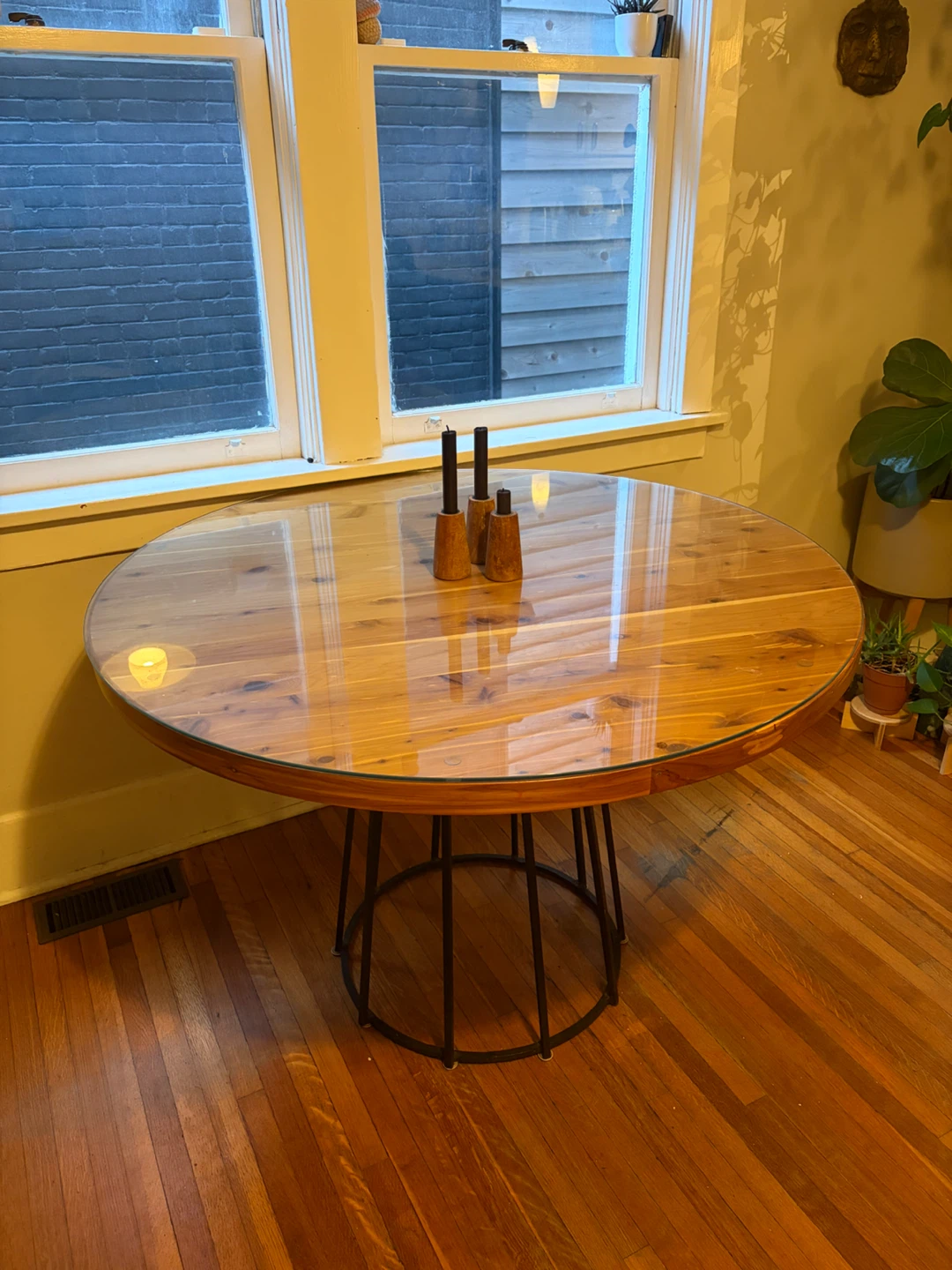 Round wooden dining table with glass top