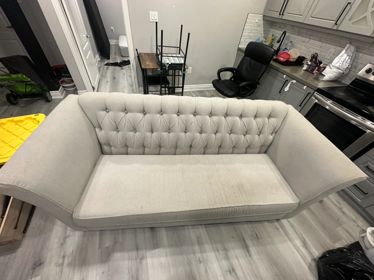 Light grey tufted sofa with crystal buttons