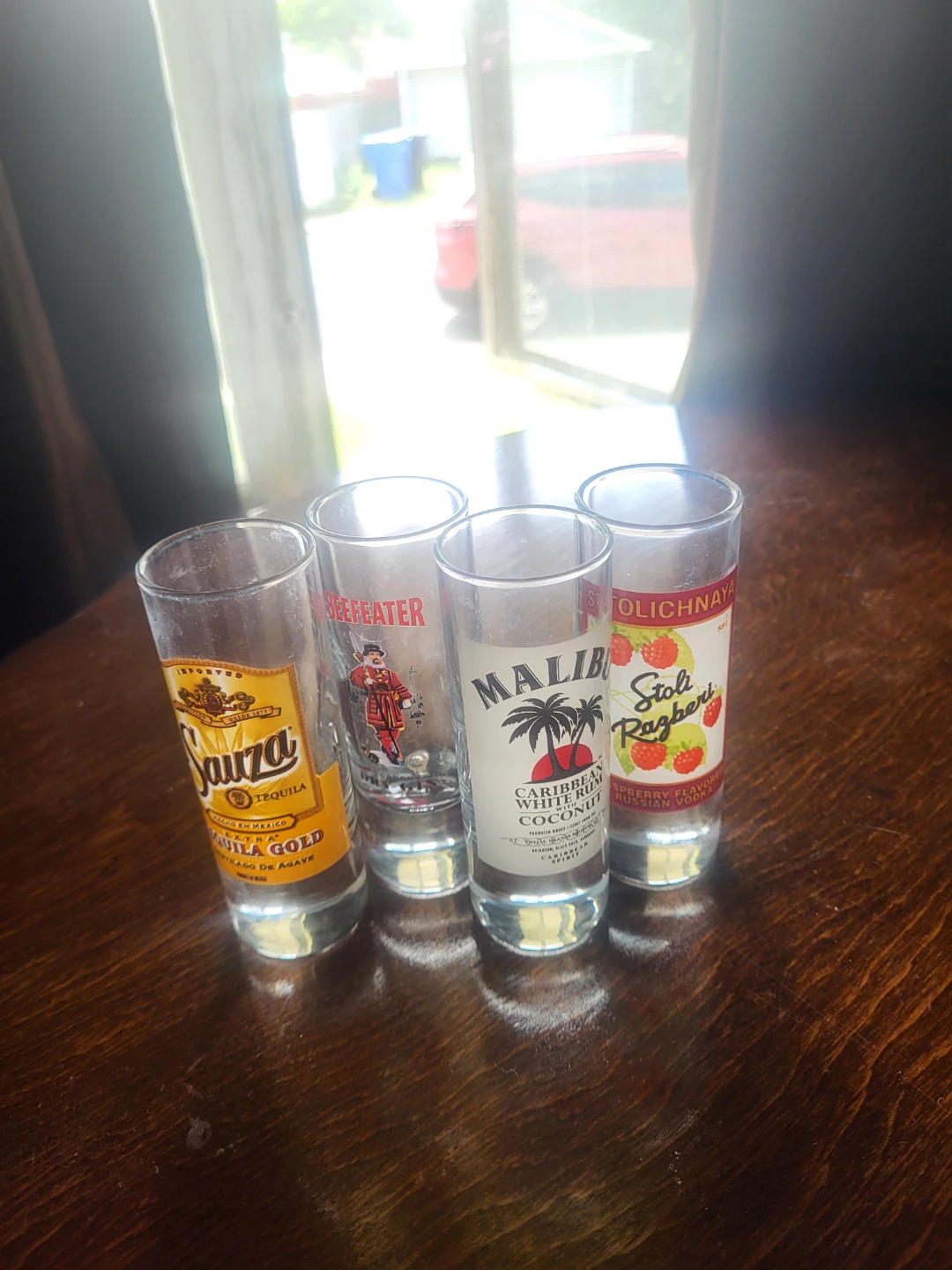 Lot of 4 Shot Glasses: Sauza, Beefeater, Malibu, Stoli Razberi