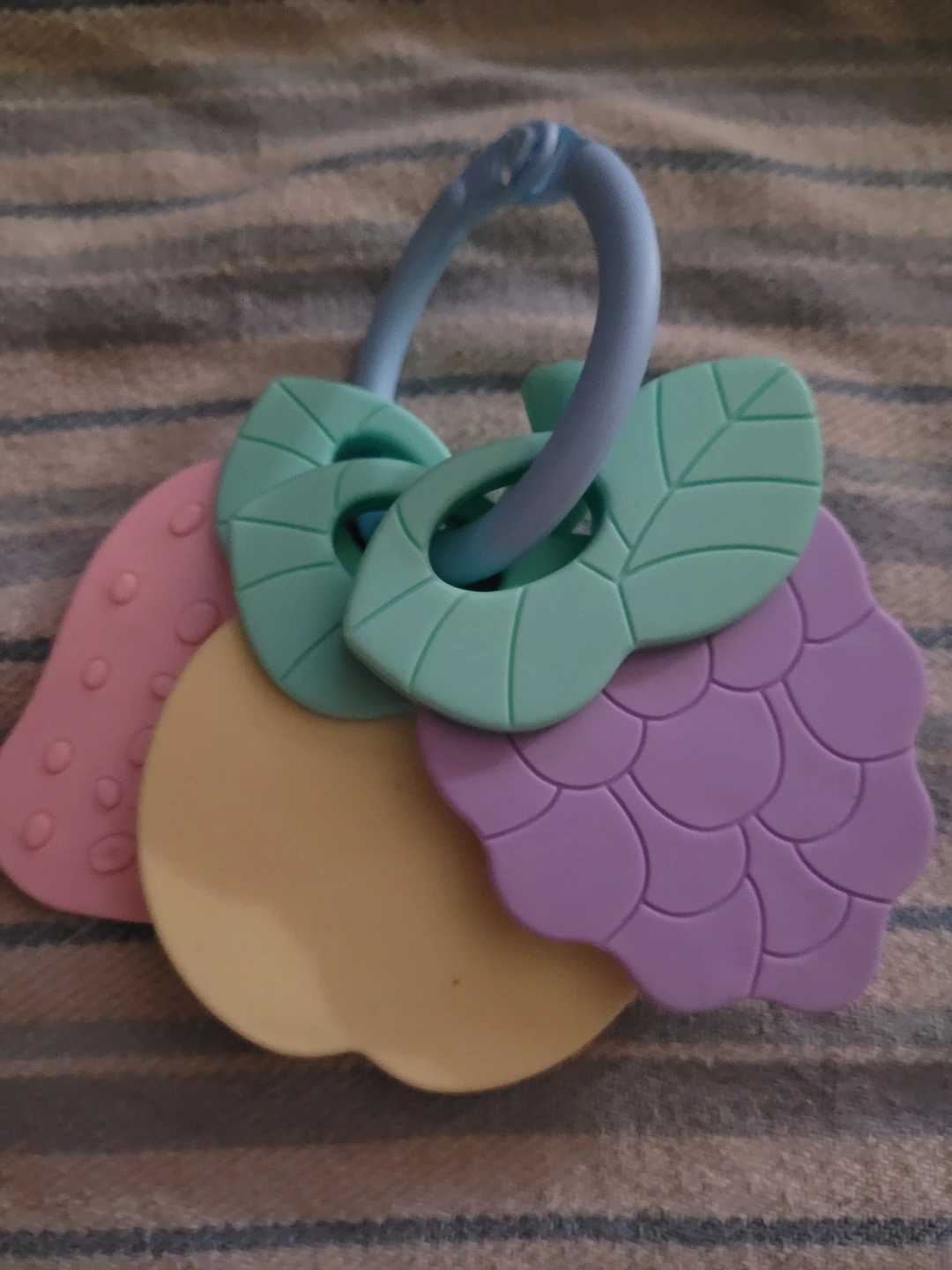 fruit-shaped baby teething toy set with a blue holding ring.