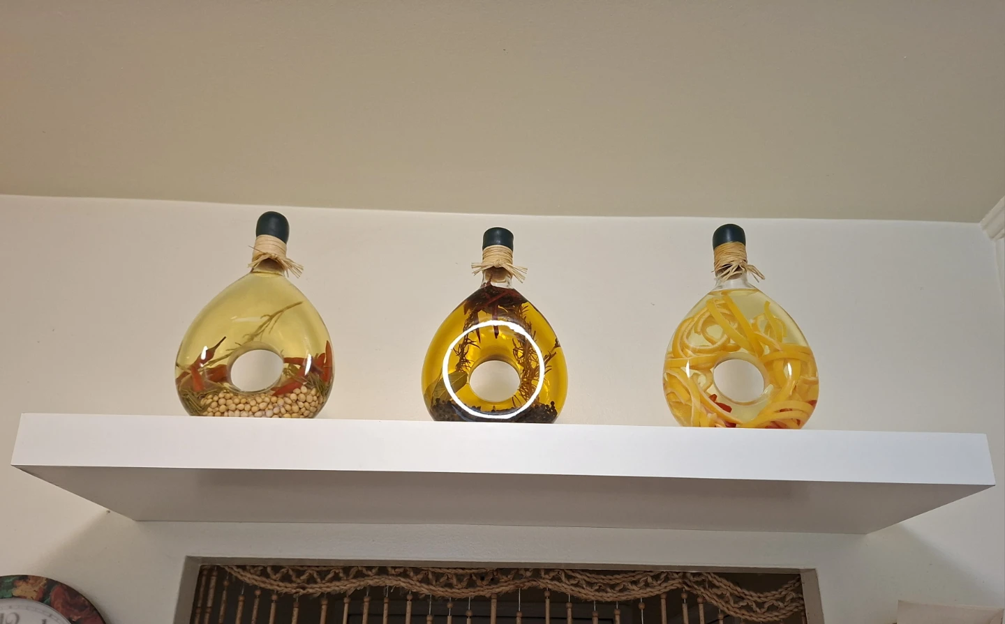 Decorative Infused Oil Bottles & a white shelf