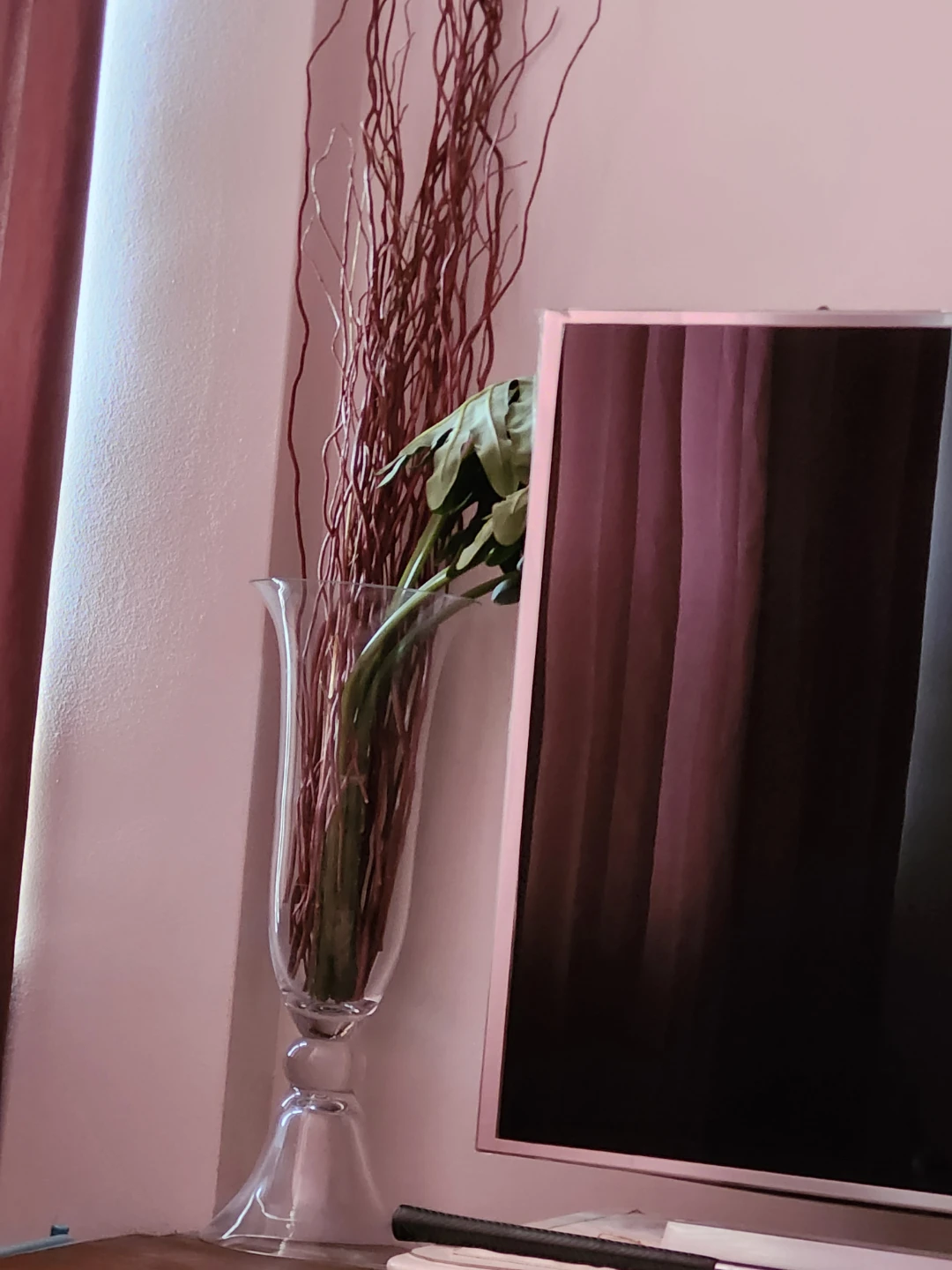Clear glass pedestal vase with decorative branches