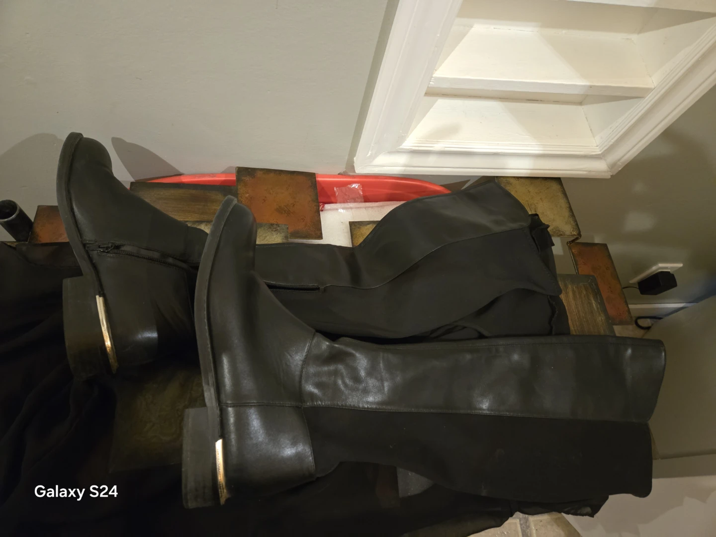 Black over-the-knee boots with gold heel detail