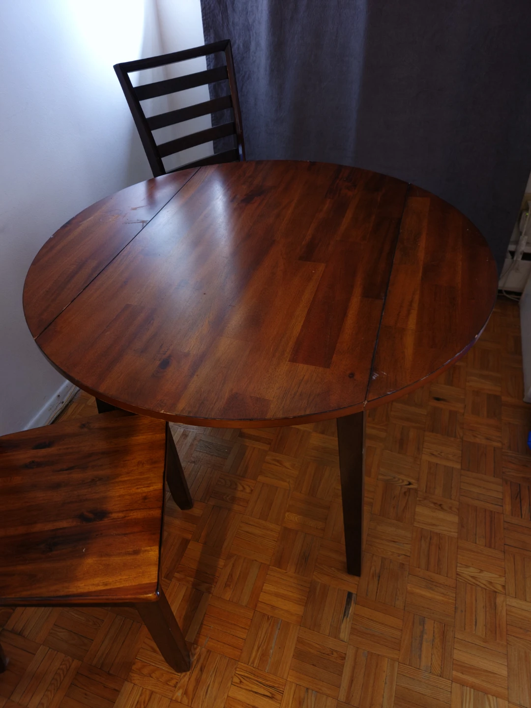 Round wooden dining table with two chairs