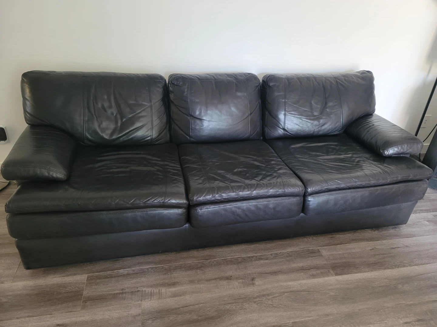Black leather three-seater sofa