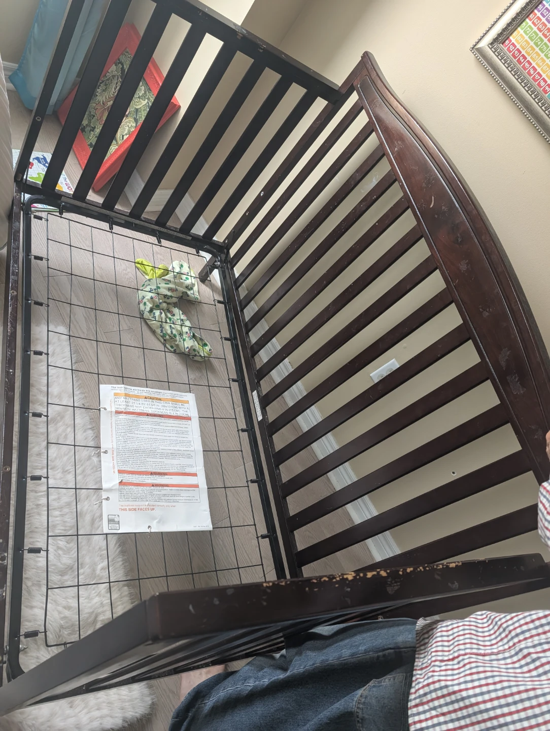 Dark brown wooden baby crib has marks