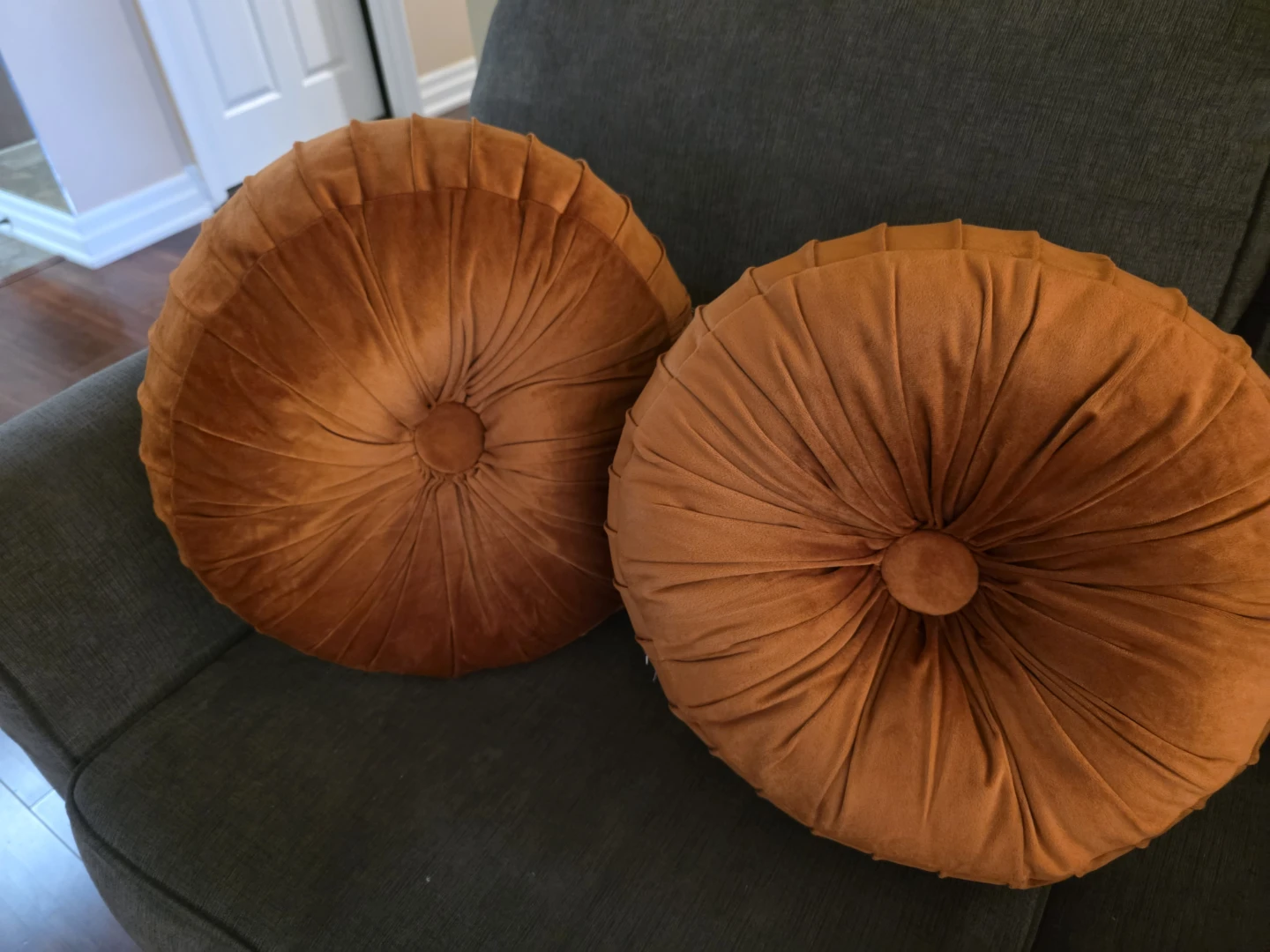 Two round rust velvet cushions