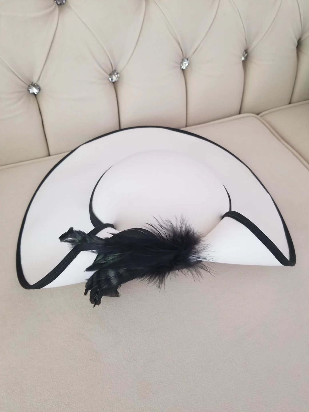 White wide-brim hat with black feather