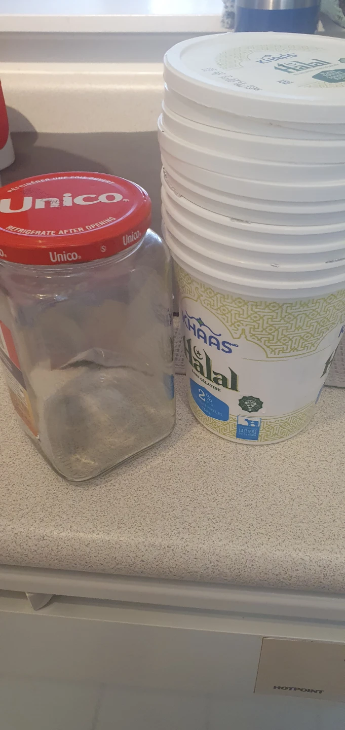 Empty glass jar and stack of plastic yogurt containers