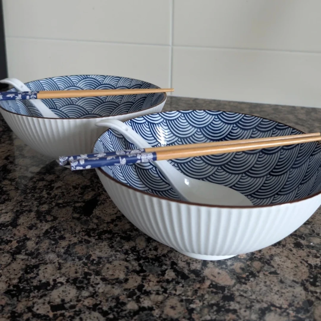 Two Japanese-style ramen bowls w/ spoons and chopsticks.