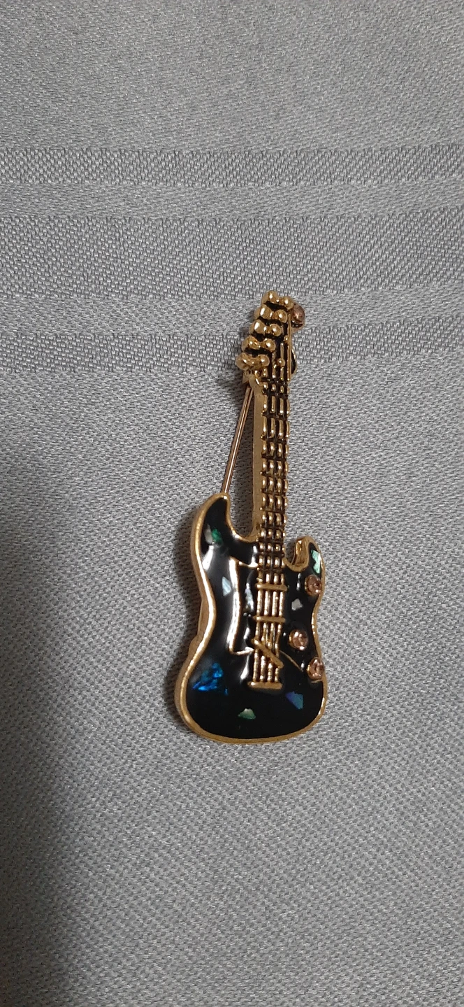Guitar-shaped brooch, intricate details.