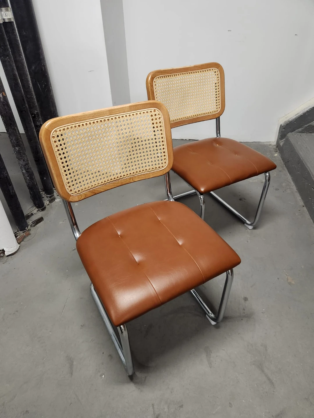 Set of two cane and leather dining chairs