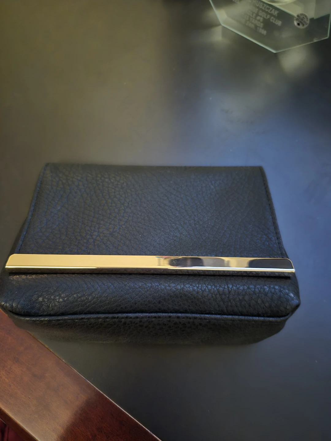 Black leather cosmetic bag with gold-tone accent