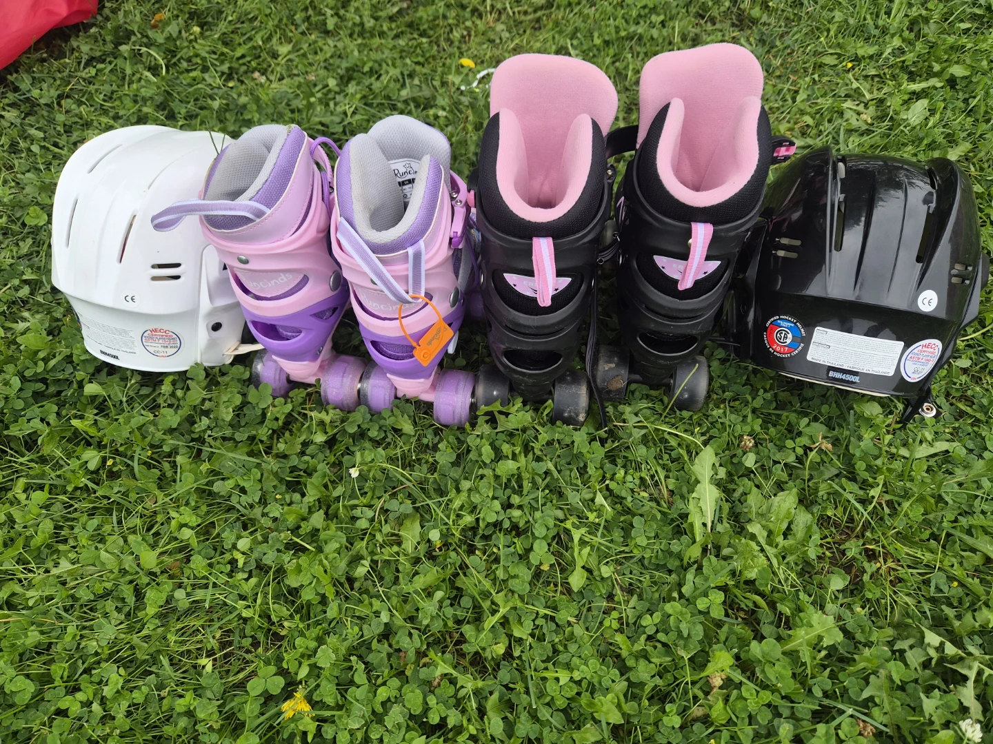 Two Pairs of Kids Roller Skates and Two Bauer Helmets
